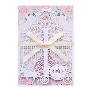 Detail of laser-cut pumpkin carriage wedding invitation with cream satin ribbon bow