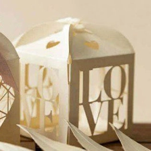 Close-up of ivory wedding candy box with laser-cut LOVE text and heart hollow patterns
