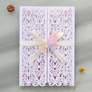 Détail de l'invitation de mariage découpée au laser avec ruban de soie et papillon
