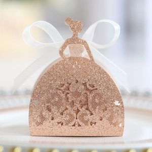 Macro detail of laser-cut lace pattern and glitter finish on a rose gold gown candy box