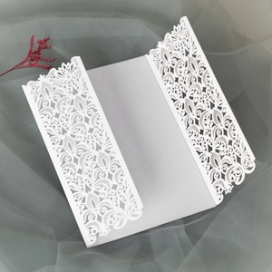 Détail de l'invitation de mariage blanche découpée au laser avec motif floral