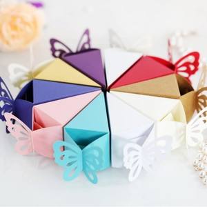 Colorful butterfly laser cut triangular favor boxes arranged in a cake circle