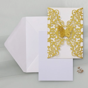 Macro view of champagne glitter butterfly laser cut invitation cover with blank inserts