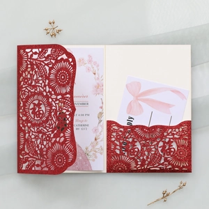Macro shot of red glitter laser-cut wedding invitation featuring Fu character and floral insert