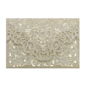 Detail of laser-cut European floral pattern on champagne gold glitter wedding invitation