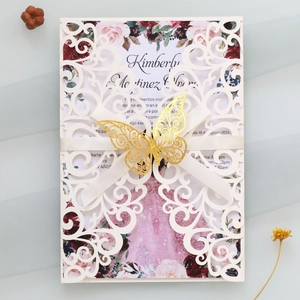 Détail d'invitation de mariage découpée au laser avec décorations florales et papillon doré