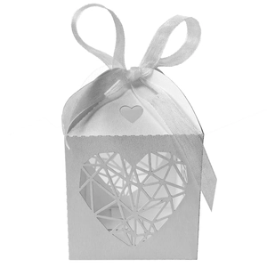 Détail boîte à bonbons ivoire avec motif de cœur évidé et nœud en ruban de soie