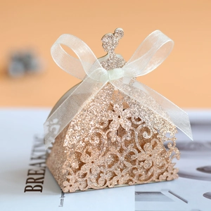 Detail of laser-cut flower dress candy box with glitter finish and ribbon bow