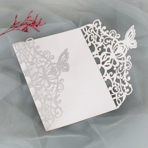 Detail of silver glitter butterfly card with laser-cut lace pattern and red dried flower