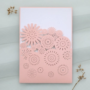 Intricate laser-cut pink floral wedding invitation pocket with elegant white inner card