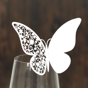 Laser-cut white butterfly place cards for wine glass decoration in elegant weddings
