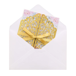 Détail de l'invitation de mariage dorée découpée au laser avec ruban et carte fleurie