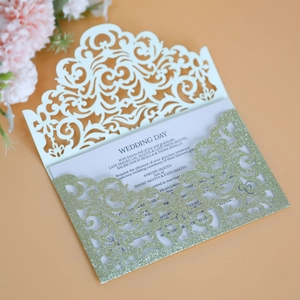 Detail of laser-cut wedding invitation with glitter border and elegant floral accents
