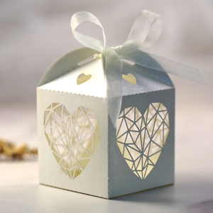 Détail macro de boîte cadeau ajourée en cœur avec ruban satiné bleu et fini perlé élégant
