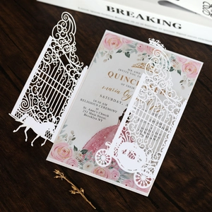 Detail of laser-cut wedding invitation featuring carriage design and pink floral inner card
