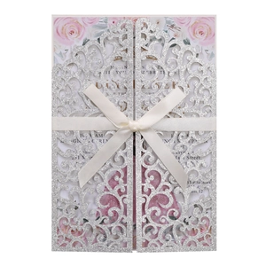 Détail de l'invitation de mariage pailletée argentée avec nœud en soie et motif floral