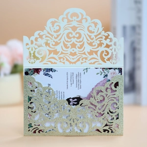 Detail of laser-cut wedding invitation with glitter gold envelope and floral insert card