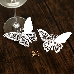 Élégants marque-places papillon blancs découpés au laser sur table en bois pour mariage