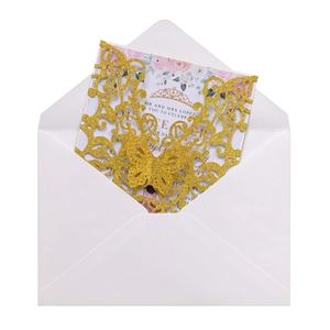 Close-up of laser-cut glitter butterfly wedding invitation with floral insert and white envelope