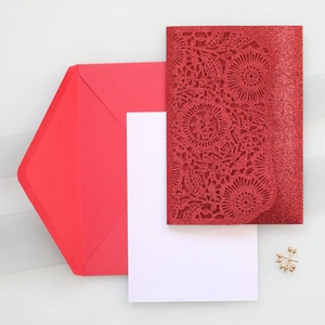Detail of red laser-cut invitation cover with glitter finish and Fu character pattern