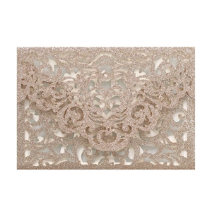 Detail of laser-cut damascus pattern on champagne gold glitter wedding invitation card