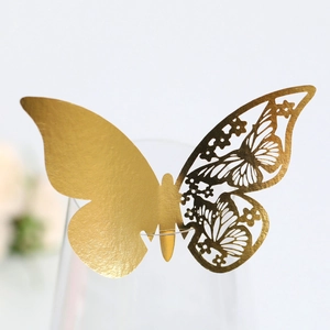 Detailed view of a gold 3D butterfly place card with laser-cut wing on a glass rim