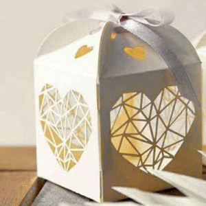 Détail de la boîte à bonbons ivoire ajourée cœur avec motif géométrique et ruban gris