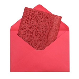 Macro detail of laser-cut red glitter invitation card with floral mandala pattern
