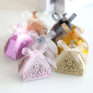 Macro view of laser-cut lace pattern on glittery gift boxes with elegant ribbon bows