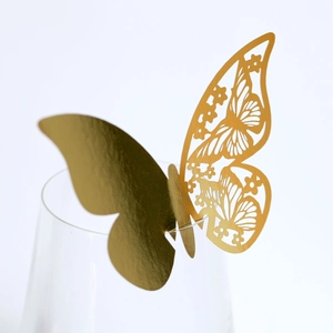 Macro view of gold laser-cut butterfly wine glass card for party and wedding decor