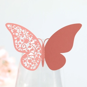 Close-up of pink butterfly laser-cut place card on wine glass for wedding party