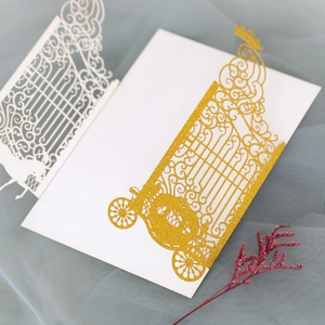 Detail of laser-cut wedding invitation featuring gold glitter hollow pumpkin carriage design
