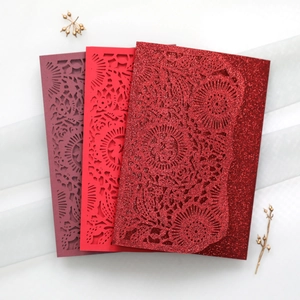Laser-cut floral invitation covers in red and purple glitter cardstock on white silk