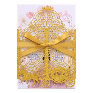 Detail of laser cut gold glitter invitation featuring pumpkin carriage and ribbon