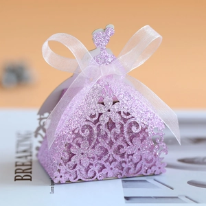 Macro detail of laser-cut pink glitter candy box in princess dress shape with ribbon