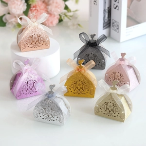 Detailed laser-cut glitter paper gift boxes in elegant dress shapes with organza bows