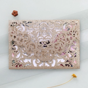 Close-up of glitter laser-cut wedding invitation shell with delicate floral card