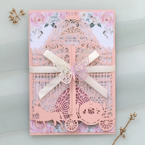 Detail of pink laser-cut wedding invitation featuring elegant carriage and 3D butterfly