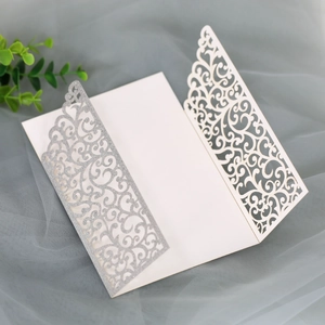 Détail d'une invitation découpée au laser avec paillettes argentées et motifs de vigne ivoire