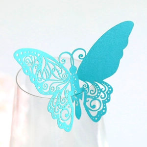 Vue macro d'une carte papillon découpée au laser bleu cyan avec reflet nacré