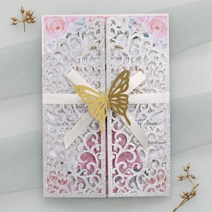 Détail de l'invitation de mariage pailletée découpée au laser avec papillon doré et fleurs