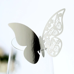 Close-up of a silver butterfly glass card with hollow floral patterns and mirror finish