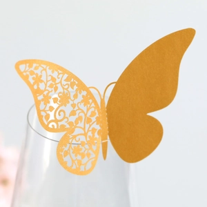 Macro shot of laser-cut golden butterfly glass card with floral hollow pattern