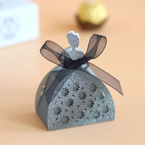 Close-up of laser-cut lace flower detail on wedding dress shape candy box with bow