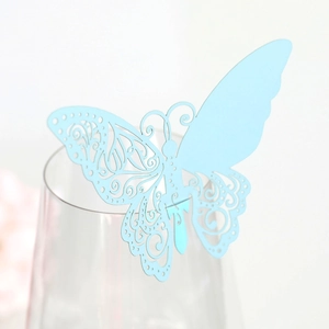 Gros plan d'un marque-place papillon bleu clair découpé au laser sur un verre