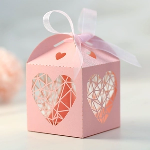 Détail de la boîte de mariage rose découpée au laser avec cœur et ruban rose