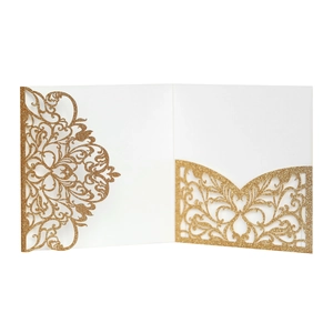 Close-up of laser-cut damascus floral patterns on glittery gold wedding invitation cover