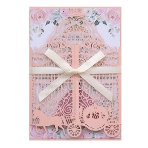 Detail of pink laser-cut wedding invitation with silk bow and floral insert