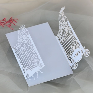 Detailed laser cut wedding invitation featuring intricate carriage and gate scroll patterns