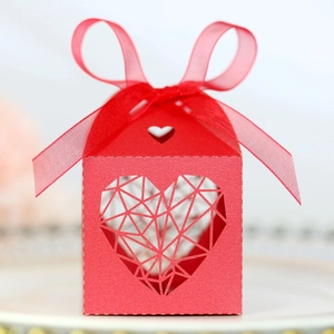 Détail de la boîte à bonbons rouge découpée au laser avec motif cœur et ruban en soie